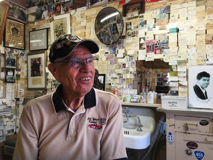 Angel Delgadillo gazes out his window toward Route 66 in his barber shop