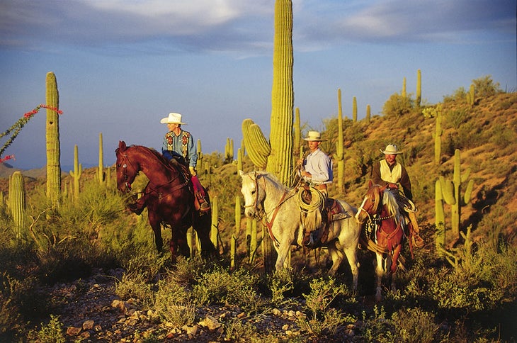 Three cowboys in the desert near Rancho de los Caballeros Guest Ranch