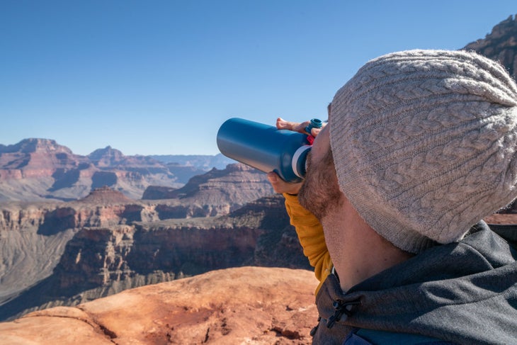 Man drinking water from a reusable water bottle at the Grand Canyon